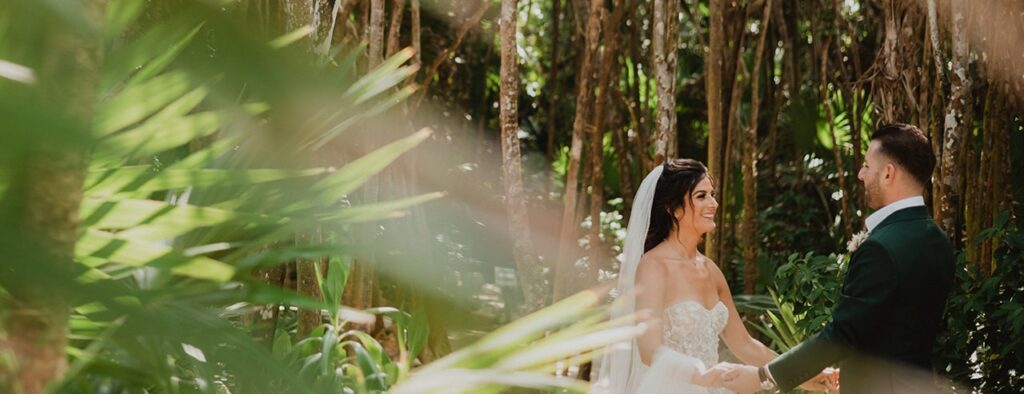 Bride and groom smiling at each other endearingly during Relaxed Papaya Playa Project wedding shoot